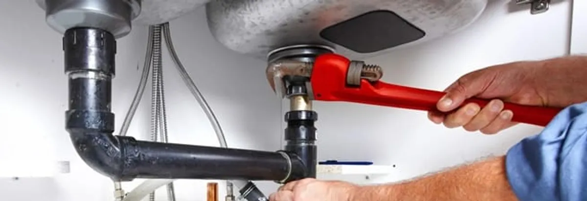 Garbage disposal repair technician tightening the sink drain and disposal connection in Cambridge, MA