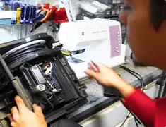 Vacuum repair technician servicing internal components on a workbench in Cambridge, MA