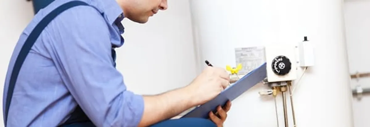 Water heater repair technician inspecting the unit and recording service notes in Cambridge, MA